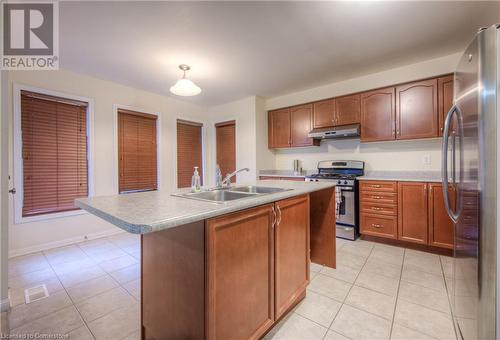 Kitchen featuring light tile patterned floors, sink, a kitchen island with sink, and appliances with stainless steel finishes - 66 Abbott Crescent, Cambridge, ON - Indoor Photo Showing Kitchen With Double Sink