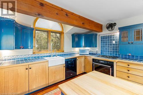 Kitchen features custom cabinetry, built in appliances and natural wood accents. - 92 Moore St, Lion'S Head, ON - Indoor Photo Showing Kitchen