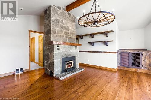 Large den with vaulted ceilings and custom cut-stone fireplace with efficient air-tight wood insert. - 92 Moore St, Lion'S Head, ON - Indoor Photo Showing Other Room With Fireplace