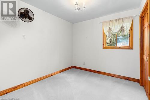 2nd main floor bedroom with double door closet and wood accents. - 92 Moore St, Lion'S Head, ON - Indoor Photo Showing Other Room