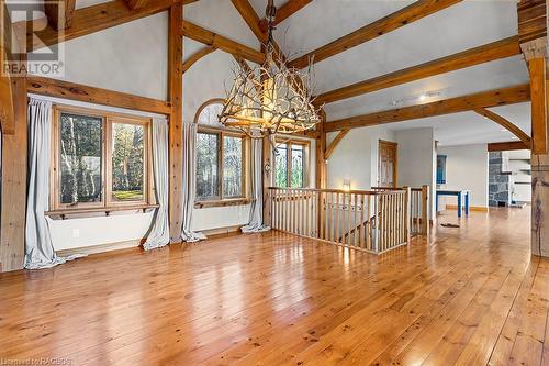 Open dining room area with custom chandelier, gleaming wood-flooring and load of natural light. - 92 Moore St, Lion'S Head, ON - Indoor Photo Showing Other Room