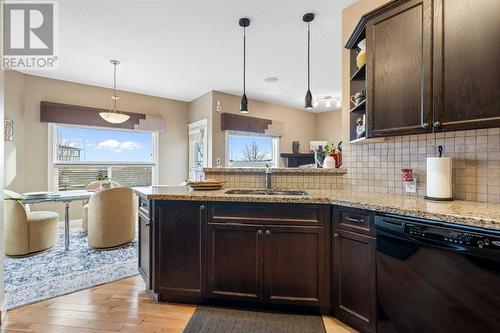 The kitchen features granite countertops, a generous dining area, a raised bar - 111 Sage Hill Green Nw, Calgary, AB 