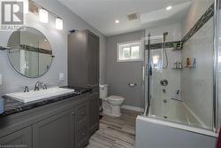 Full bathroom with toilet, vanity, and shower / bath combination with glass door - 