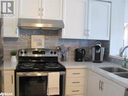 Kitchen featuring white cabinetry, sink, and stainless steel range with electric cooktop - 