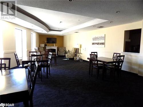 Dining space with a tray ceiling, a textured ceiling, and dark colored carpet - 150 E Dunlop Street E Unit# 605, Barrie, ON 