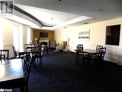 Dining space with a tray ceiling, a textured ceiling, and dark colored carpet - 