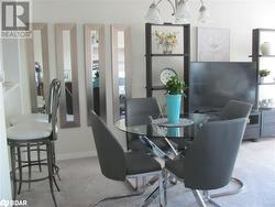 Dining space featuring a chandelier, light colored carpet, and a healthy amount of sunlight - 