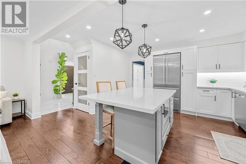 Kitchen featuring stainless steel built in fridge, a center island, hanging light fixtures, a kitchen breakfast bar, and white cabinetry - 2401 Coventry Way, Burlington, ON 