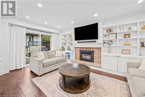 Living room with a fireplace, hardwood / wood-style flooring, and crown molding - 2401 Coventry Way, Burlington, ON 