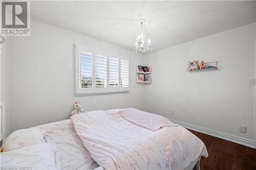 Bedroom featuring dark hardwood / wood-style flooring, a chandelier, and a textured ceiling - 2401 Coventry Way, Burlington, ON 