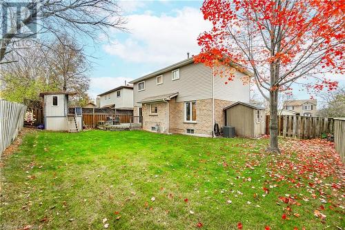 Rear view of property with a storage unit, a lawn, and central AC - 2401 Coventry Way, Burlington, ON 