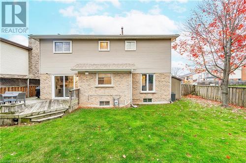 Rear view of house featuring cooling unit, a yard, and a wooden deck - 2401 Coventry Way, Burlington, ON 