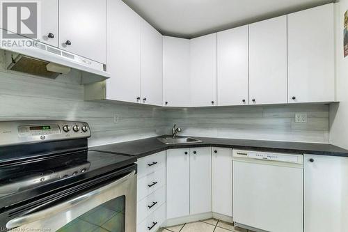 Kitchen featuring dishwasher, light tile patterned floors, sink, white cabinetry, and stainless steel electric range oven - 48 Windom Road Unit# E, Kitchener, ON 