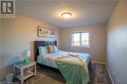 Bedroom with dark colored carpet and a textured ceiling - 418 White Birch Avenue, Waterloo, ON 