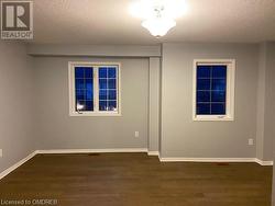 Empty room with dark wood-type flooring and a textured ceiling - 