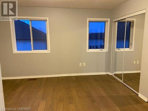 Unfurnished bedroom featuring a closet, hardwood / wood-style floors, and a textured ceiling - 710 Spring Gardens Road Unit# 32, Burlington, ON 