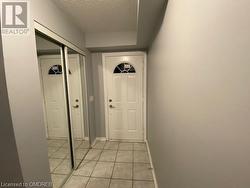 Doorway to outside featuring a textured ceiling and light tile patterned floors - 