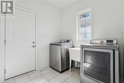 Washroom featuring separate washer and dryer and light tile patterned floors - 