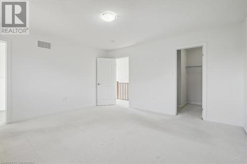 Unfurnished bedroom with light carpet, a walk in closet, and a closet - 21 White Star Lane, Grimsby, ON 