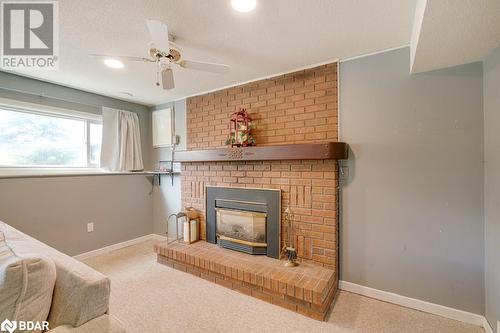 Living room featuring a textured ceiling, light carpet, and ceiling fan - 47 Westfield Drive, St. Catharines, ON - Indoor Photo Showing Living Room With Fireplace