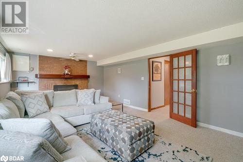 Carpeted living room featuring a brick fireplace, ceiling fan, and a textured ceiling - 47 Westfield Drive, St. Catharines, ON - Indoor Photo Showing Living Room