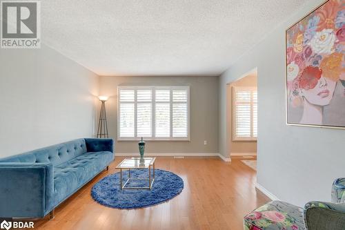 Living room featuring a wealth of natural light, wood-type flooring, and a textured ceiling - 47 Westfield Drive, St. Catharines, ON - Indoor Photo Showing Living Room