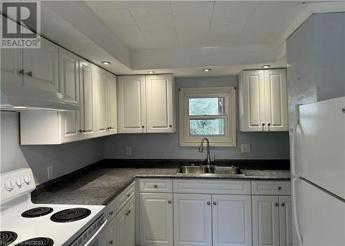 Kitchen with white cabinetry, white appliances, and sink - 941 20Th Street W, Georgian Bluffs, ON - Indoor Photo Showing Kitchen With Double Sink