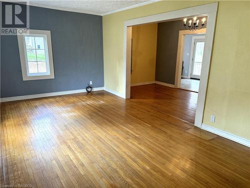 Empty room featuring hardwood / wood-style floors, plenty of natural light, crown molding, and an inviting chandelier - 941 20Th Street W, Georgian Bluffs, ON - Indoor Photo Showing Other Room