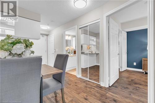 Dining area featuring dark wood-type flooring and a textured ceiling - 2379 Central Park Drive Unit# 206, Oakville, ON - Indoor