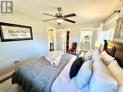 Bedroom with ceiling fan and a walk in closet - 