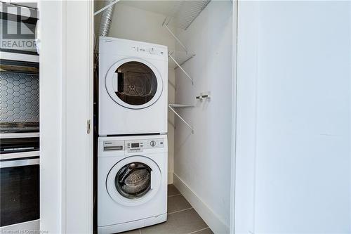 Laundry room featuring stacked washer / drying machine and tile patterned floors - 15 Prince Albert Boulevard Unit# 610, Kitchener, ON - Indoor Photo Showing Laundry Room