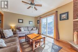 Living room with wood-type flooring and ceiling fan - 