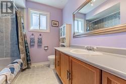 Full bathroom with toilet, vanity, shower / bath combination with curtain, and tile patterned flooring - 