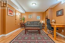 Office with dark wood-type flooring and ornamental molding - 