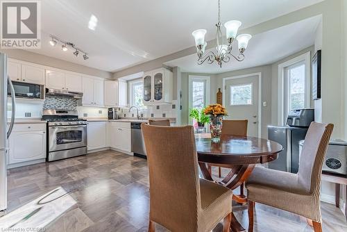 Kitchen featuring white cabinets, appliances with stainless steel finishes, pendant lighting, and plenty of natural light - 2080 Sixth Line, Oakville, ON - Indoor