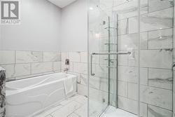 Bathroom with shower with separate bathtub and tile walls - 