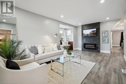 Living room featuring wood-type flooring and a tiled fireplace - 59 Stanley Street, Brantford, ON - Indoor Photo Showing Living Room