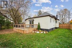 Rear view of property featuring a lawn and a deck - 