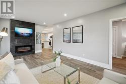 Living room with hardwood / wood-style flooring and a tile fireplace - 