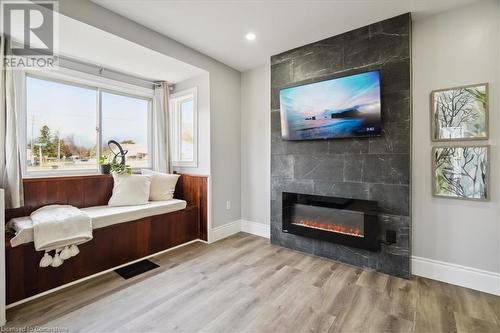 Sitting room with a tiled fireplace and light hardwood / wood-style floors - 59 Stanley Street, Brantford, ON - Indoor Photo Showing Living Room With Fireplace