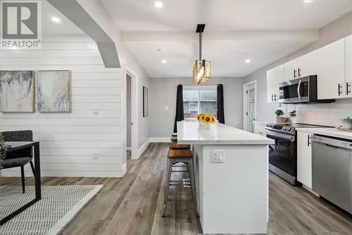 Kitchen with appliances with stainless steel finishes, light hardwood / wood-style flooring, pendant lighting, white cabinets, and a center island - 59 Stanley Street, Brantford, ON - Indoor Photo Showing Kitchen With Stainless Steel Kitchen With Upgraded Kitchen