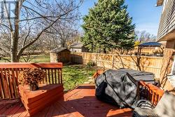 Wooden deck featuring grilling area and a storage shed - 