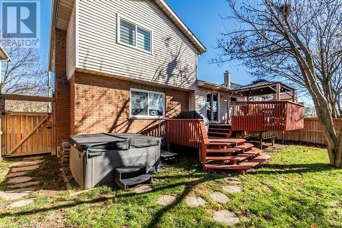 Back of property featuring a hot tub, a lawn, and a wooden deck - 56 Imperial Road N, Guelph, ON - Outdoor With Deck Patio Veranda