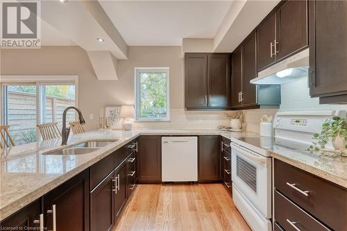 Kitchen featuring white appliances, sink, light hardwood / wood-style flooring, and a wealth of natural light - 262 Homewood Avenue, Hamilton, ON - Indoor Photo Showing Kitchen With Double Sink