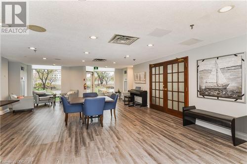 Dining area with hardwood / wood-style floors, a textured ceiling, and french doors - 2511 Lakeshore Road W Unit# 108, Oakville, ON - Indoor