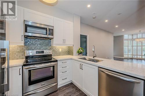 Kitchen with white cabinetry, sink, and stainless steel appliances - 2511 Lakeshore Road W Unit# 108, Oakville, ON - Indoor Photo Showing Kitchen With Double Sink With Upgraded Kitchen