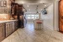 Kitchen featuring tasteful backsplash, appliances with stainless steel finishes, dark brown cabinets, and a breakfast bar - 52 Adam Street, Cambridge, ON  - Indoor Photo Showing Kitchen 