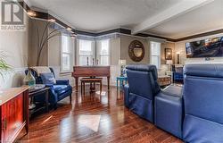 Living room with ornamental molding, beamed ceiling, and dark hardwood / wood-style floors - 