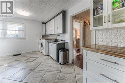 Laundry room featuring cabinets, separate washer and dryer, sink, and light tile patterned flooring - 