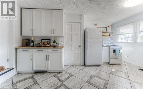 Kitchen with butcher block counters, white cabinetry, electric stove, white refrigerator, and decorative backsplash - 52 Adam Street, Cambridge, ON - Indoor Photo Showing Kitchen